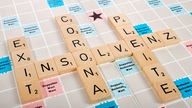 Die Begriffe "Insolvenz", "Exit", "Corona" und "Pleite" auf einem Scrabble-Spielbrett