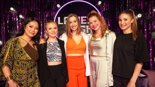 Fünf Frauen lächeln in die Kamera, im Hintergrund ein Bühnenvorgang mit dem Logo der Ladies Night.