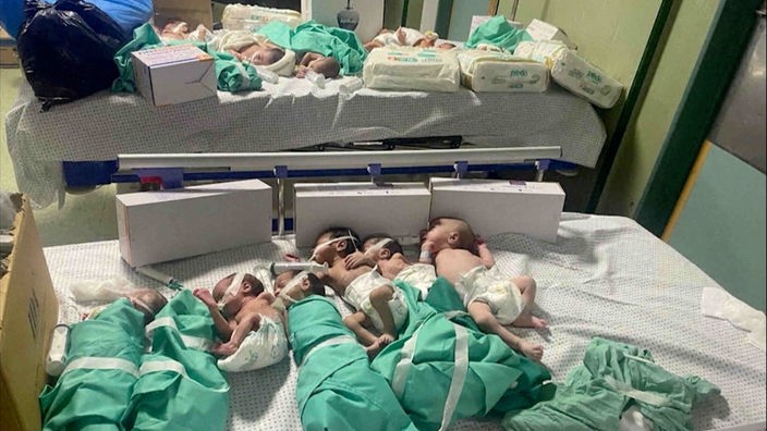 Mehrere kleine Babys, die nebeneinander auf einem Krankenhausbett liegen