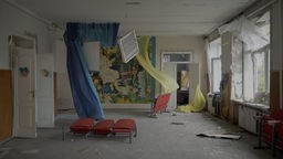 Filmstill des Films "Intercepted", der im Rahmen der Ukrainischen Filmtage NRW gezeigt wird: Ein verlassenes und verwüstetes Zimmer mit offenen Fenstern,