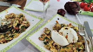 Salat aus rohen Artischocken mit Burrata auf einem Teller angerichtet