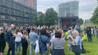 Menschen auf der Wiese vor dem Düsseldorfer Landtag demonstrieren gegen den Kita-Kollaps